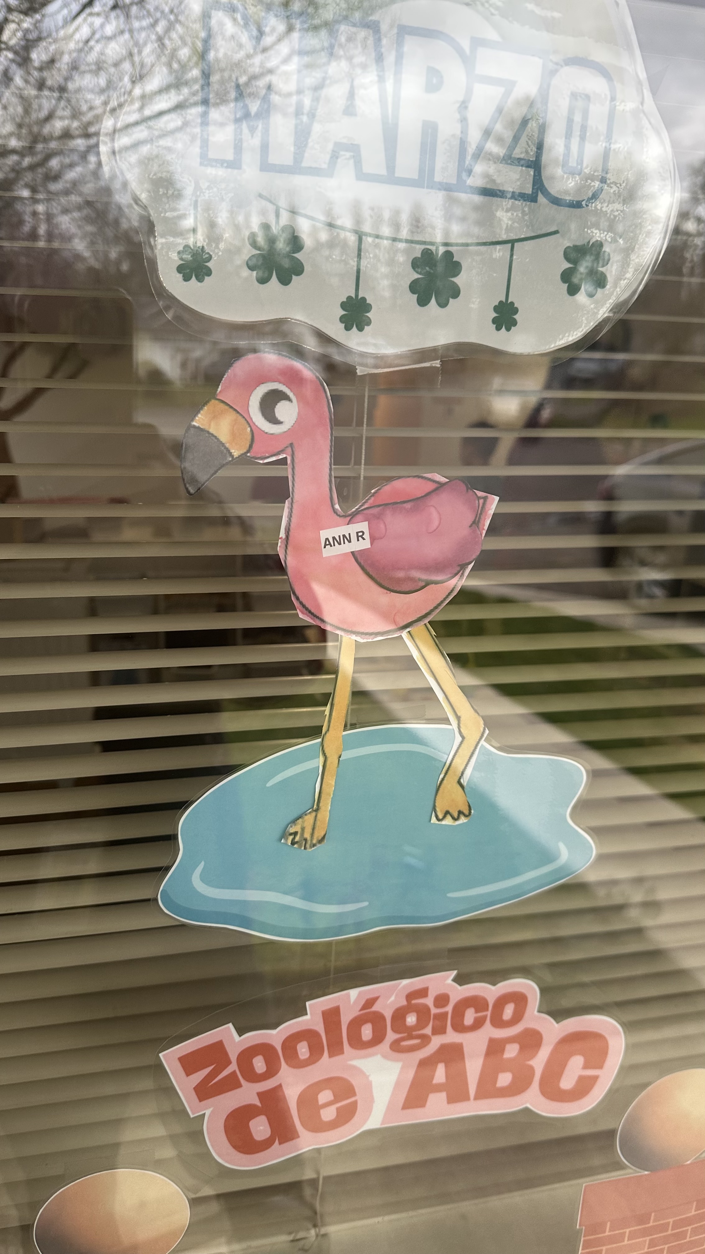 Kid-made flamingo art in a window
